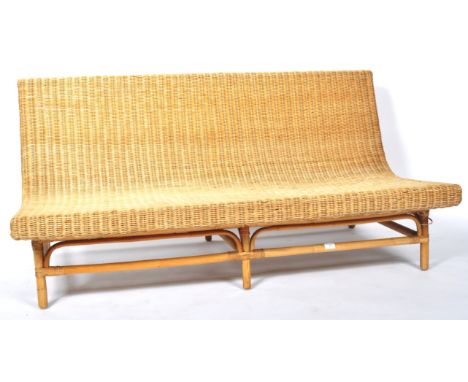 A retro 20th Century wicker / cane and bamboo bench / sofa settee of stylish curved form having a one piece woven curved seat