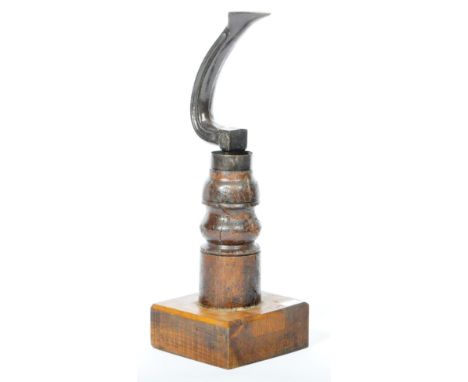 A vintage early 20th Century Cobblers' shoe last of iron construction raised and mounted upon a turned wood column upon an oa