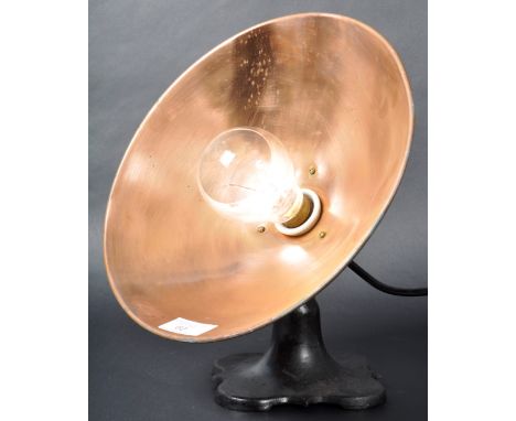 An early 20th Century Art Deco copper and cast iron heat lamp converted to a table lamp light having a UFO copper shade raise