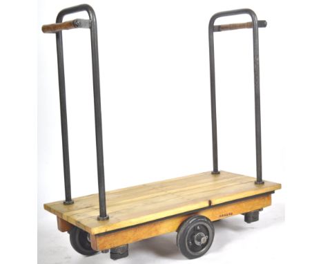 A vintage mid 20th Century railway / industrial luggage trolley having tubular metal frame supported turned oak handles to ea