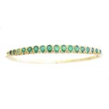 An 18ct gold emerald hinged bangle,