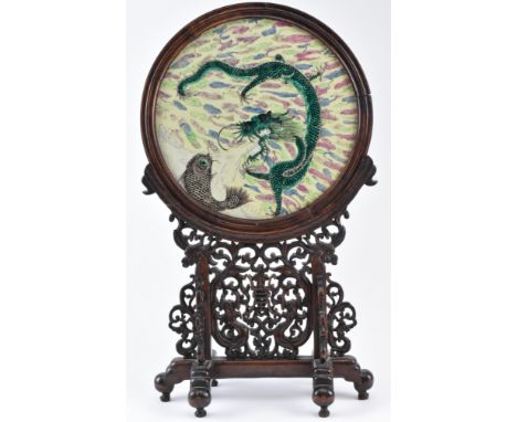 A late Qing early Republic period ceramic famille rose screen on a hardwood stand. The circular shape ceramic screen mounted 