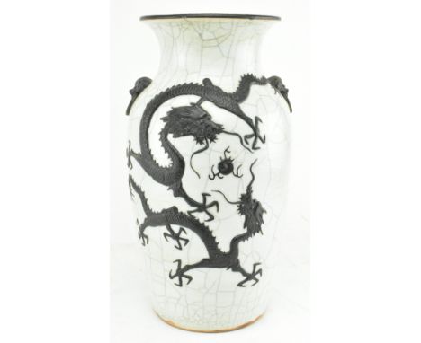 A Qing dynasty crackle glazed ceramic vase. The baluster shaped vase has a flared mouth rim, decorated with two relief dragon