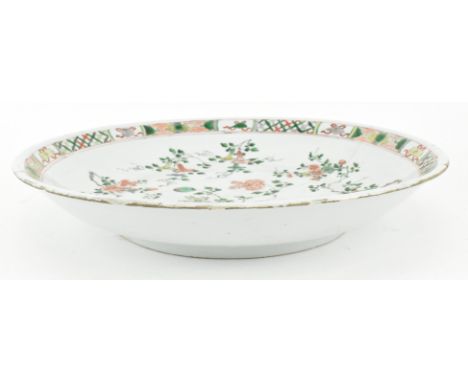 A Qing dynasty Kangxi period famille verte ceramic charger. The charger decorated with finely painted sprigs of flowers throu