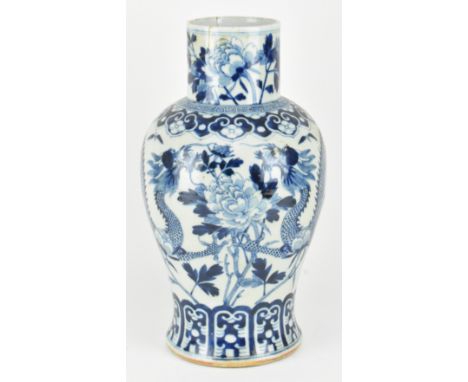A Qing dynasty blue and white "Dragon among Flowers" ceramic vase. The baluster shaped with flared mouth rim vase decorated w