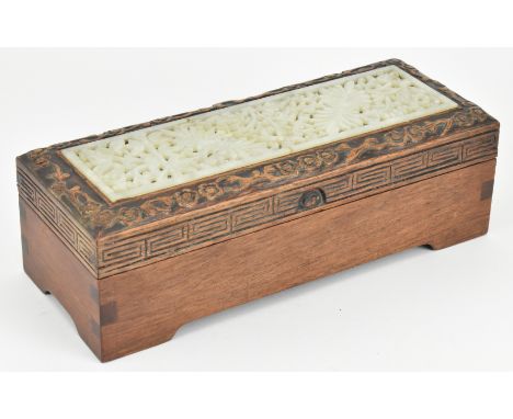 A 20th century wooden box with soapstone plaque inlaid mounted. The oblong hinged lid wooden box decorated with a soapstone j