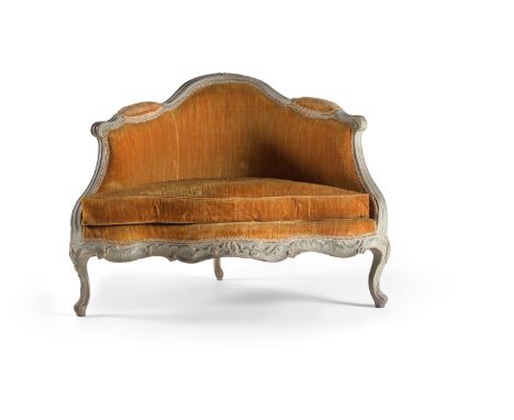 A Louis XV carved and blue painted corner bergere, mid 18th century, the moulded arched scrolling frame with gold velvet upho