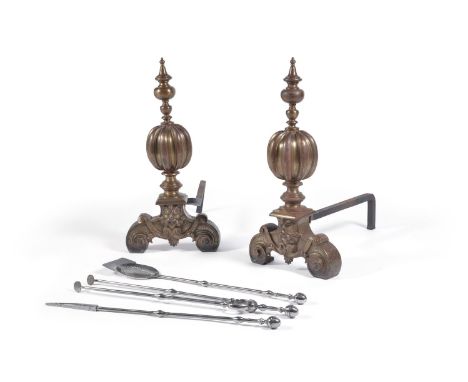 A pair of brass and wrought iron andirons in Baroque taste, the knopped finials above gadrooned ball stems descending to scro