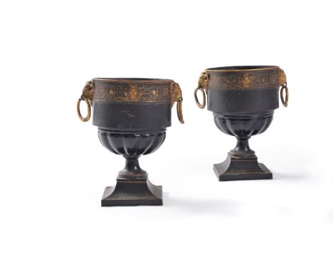 A pair of black japanned and gold painted tole jardinieres, first half 19th century, of urn form, each with twin ram’s mask a