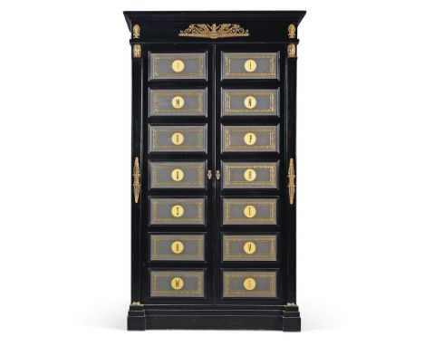 An Empire style ebonised and brass mounted armoire, 20th century, the tooled leather panelled doors labelled with the letters