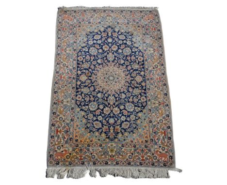 A  Nain rug, the dark blue centre ground with central ivory medallion, pink and ivory flowers, ivory border decorated with pl