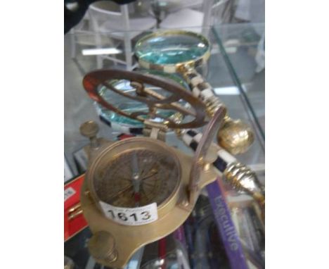 Two magnifying glasses and a brass compass.