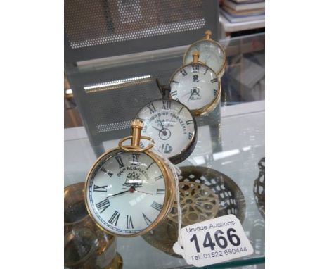 Four globe shaped desk clocks.