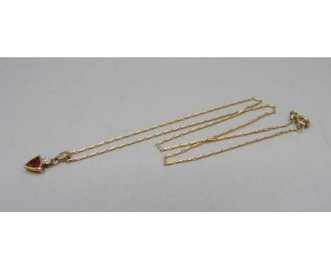 A 9ct gold, diamond and red stone pendant and chain, 2.1g 