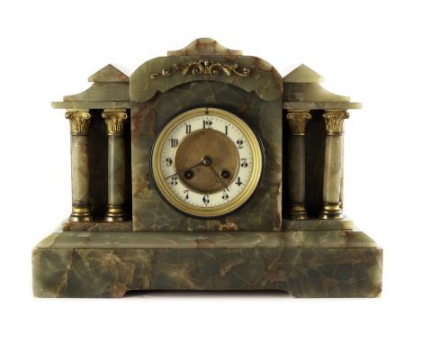 An onyx mantle clock, having architectural design, the face flanked by four columns with applied decoration