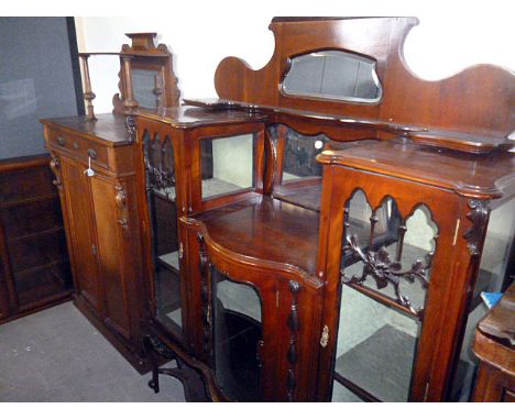 An Edwardian period English Art Nouveau display cabinet,  the mirror back surmounting a serpentine central section flanked by