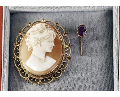 An antique gold and ruby stick pin, together with a yellow metal shell cameo brooch (2)