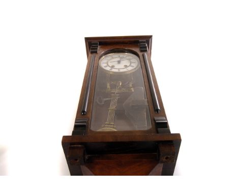 A Vienna spring driven clock, having black Roman numerals on white enamel face, in mahogany and glazed case