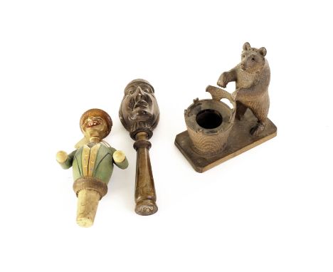 A carved Black forest Bear inkwell,  together with a "Laughing man" bottle stop and carved head nut cracker