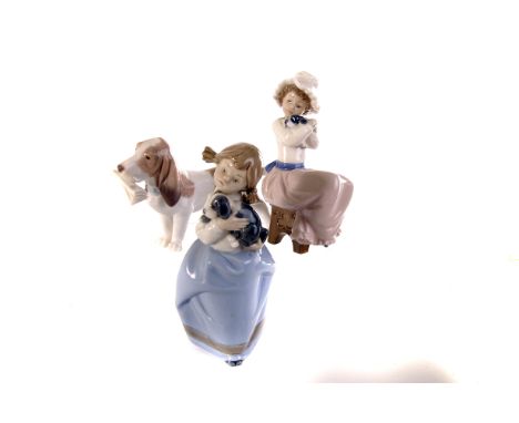 An assortment of five Lladro and Nao figures, including Girl with Lamb, 4505, a polar bear, a dog with a news paper, plus two