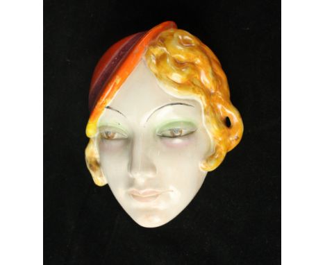 An Art Deco Goebel ceramic wall maskModelled in the form of a girl with orange side hat, impressed factory marks verso, lengt