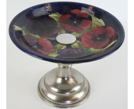 A Walter Moorcroft tazza Decorated in the 'Pansy' pattern on a blue ground, raised on chrome stand,  impressed factory marks 