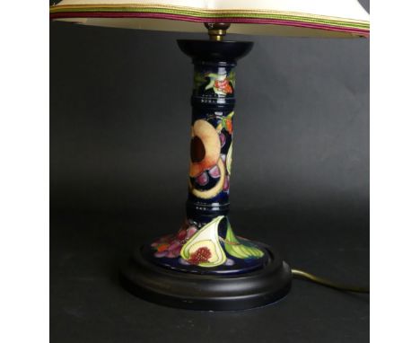 A modern Moorcroft candlestick table lampDecorated in the 'Queens Choice' pattern, designed by Emma Bossons, raised on wooden