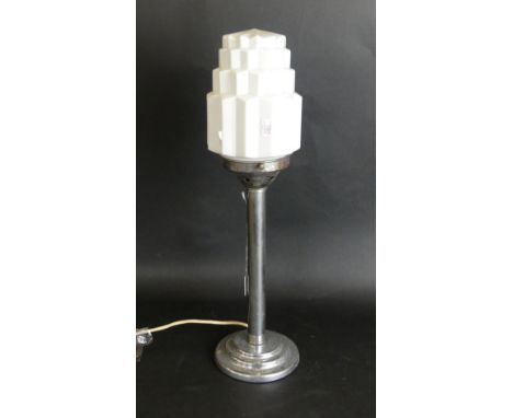 An Art Deco table lamp and shadeThe milk glass shade of stepped form, raised on chrome plated support, height 45cm, complete 