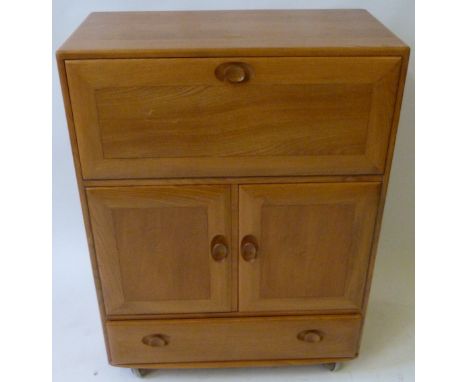 A Mid Century Ercol light elm cocktail cabinetHaving single pull down door above two further cupboard doors and single drawer