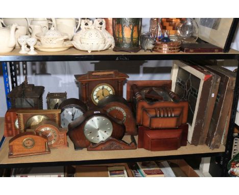 Collection of vintage mantel clocks and wall clocks together with stain glass windows and hanging lantern.