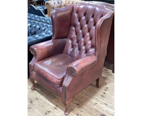 Pair button backed leather and studded wing armchairs.