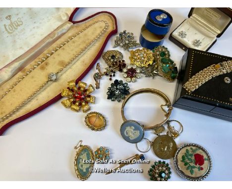 Bag of assorted costume jewellery, mostly brooches, a hinged bangle stamped gold on silver, a gold plated bracelet in a St Mo