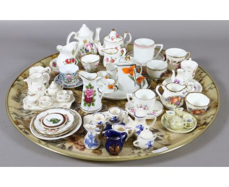 A tray of china and pottery novelty miniature tea services, cups and saucers and water jug and bowls.