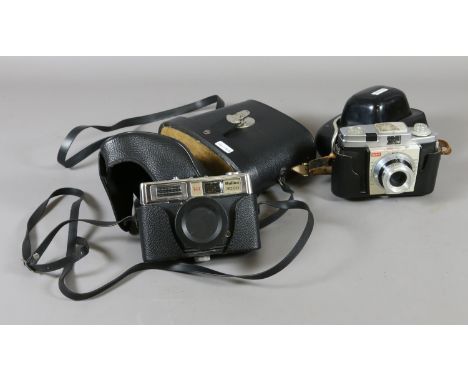 A cased Kodak camera, a cased Halina camera and a cased pair of Swallow binoculars.