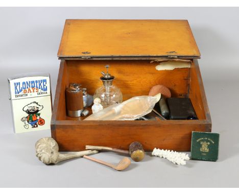 A pine table top clerks desk containing mixed collectables including oversized Zippo lighter, clay pipe and tortoise shell mo