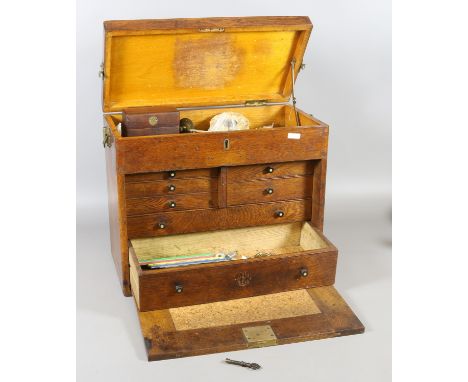 A fitted oak watch makers tool chest and contents of tools and watch parts.