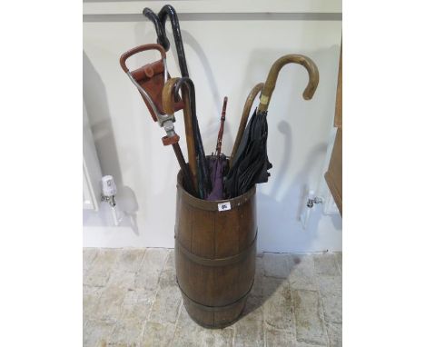 An oak barrel stick stand with contents sticks, parasols, 60cm tall 