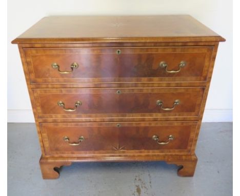 A reveneered 3 drawer chest with star inlay, standing on shaped bracket feet, 90cm tall x 95cm x 50cm 