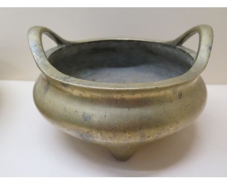 A Chinese bronze censor with raised loop handles on three feet having Xuande 6 character mark to base, 12cm tall x 19cm wide,