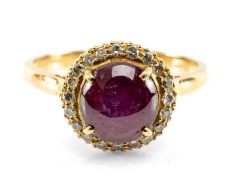 STAR RUBY & DIAMOND CLUSTER HALO RING. the ruby cabochon cut and set within a surround of circular-cut diamonds in yellow gol