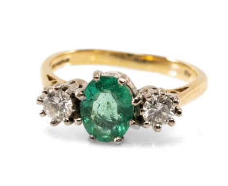 18CT GOLD EMERALD & DIAMOND THREE STONE RING, the central oval emerald (7 x 5mms approx.) flanked by two round cut diamonds (