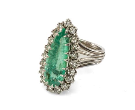 WHITE METAL EMERALD & DIAMOND CLUSTER RING, the emerald of long pear shape (19 x 7mms approx.) within border of nineteen roun