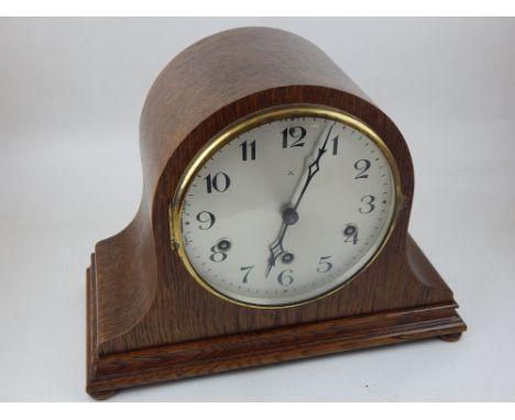 An early 20th century German oak mantel clock the eight day repeating movement with silvered dial marked Arabic numerals.