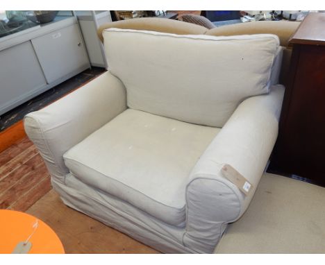 A 20th century deep upholstered single chair, covered in an oatmeal cotton fabric, together with a foot stool (2). 
