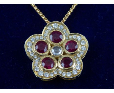 An 18ct yellow gold, ruby and diamond drop pendant necklace, modelled as a flower. 