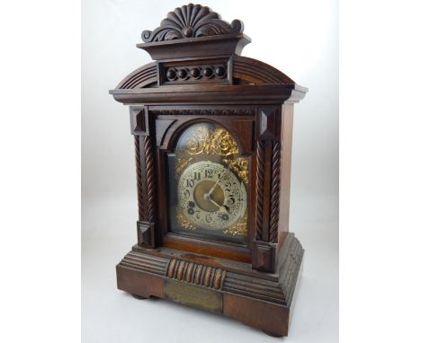 An early 20th century walnut mantel clock, the silvered dial set out in Arabic numerals within gilt spandrels, H. 44cm.