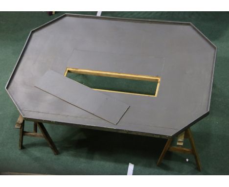 Model railway layout table, the grey table top with rectangular removable panel to the centre, raised on two trestles