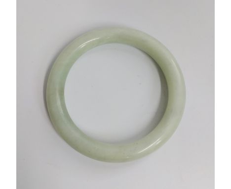 A pale green jade bangle. 
