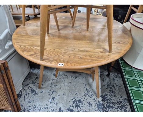An Ercol pale elm dining table and an Ercol stool frame.