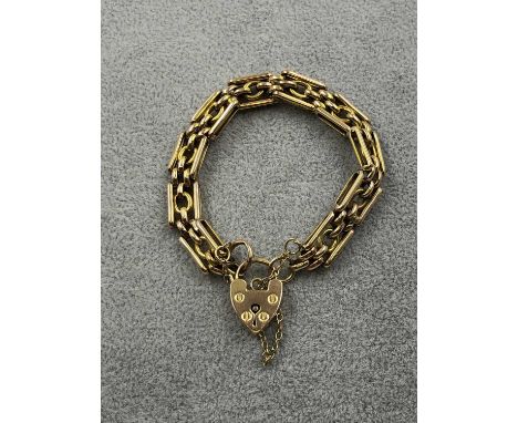 A 9ct hallmarked gold gate bracelet complete with padlock and safety chain, town mark Chester. Weight 10.51 grams. 